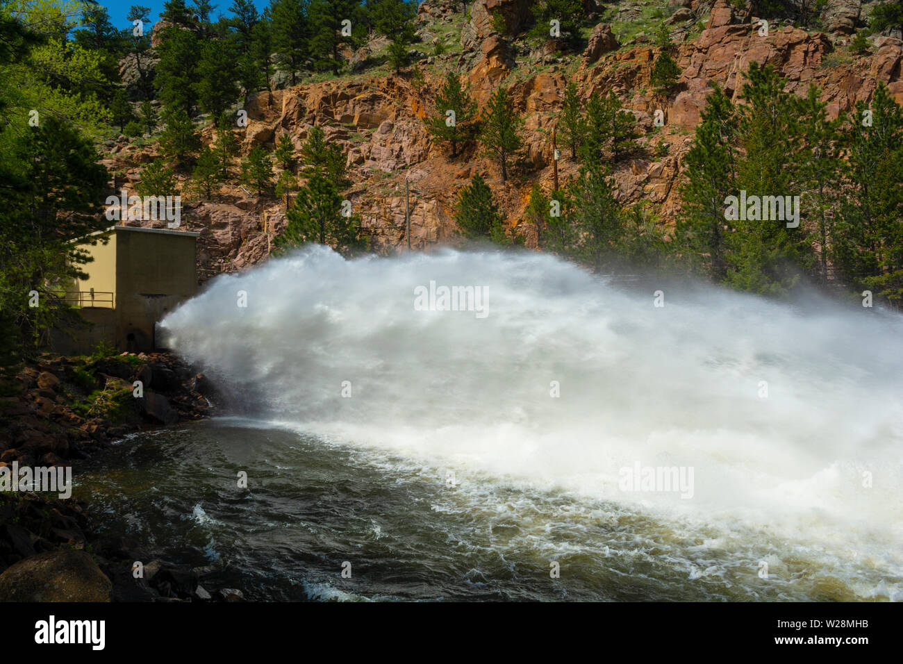 Brotes de agua desde la presa de roca Botón Floodgate en las montañas del oeste de Longmont, Colorado Foto de stock