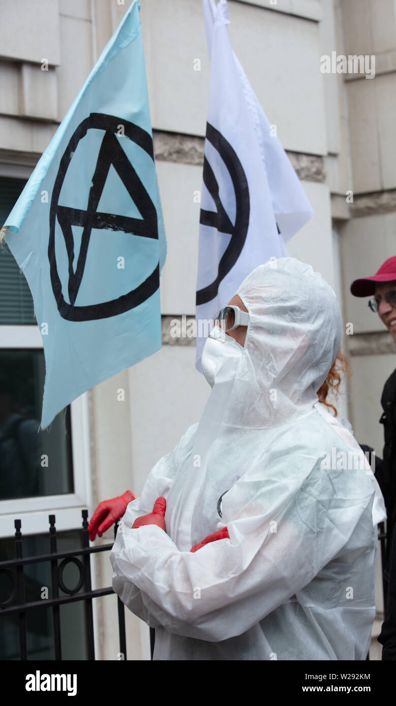 Londres, Reino Unido. El 2 de julio de 2019. Extinción rebelión Artes y Cultura Grupo creando una procesión silenciosa y teatro en frente de varias empresas de combustible fósil. La protesta play está basado en la ópera "Carmen" de Bizet, con actores de la vida real y una cantante de ópera. Foto: uno de los actores de un crimen forense blanco uniforme durante la protesta. Crédito: Joe Kuis / Alamy Noticias Foto de stock