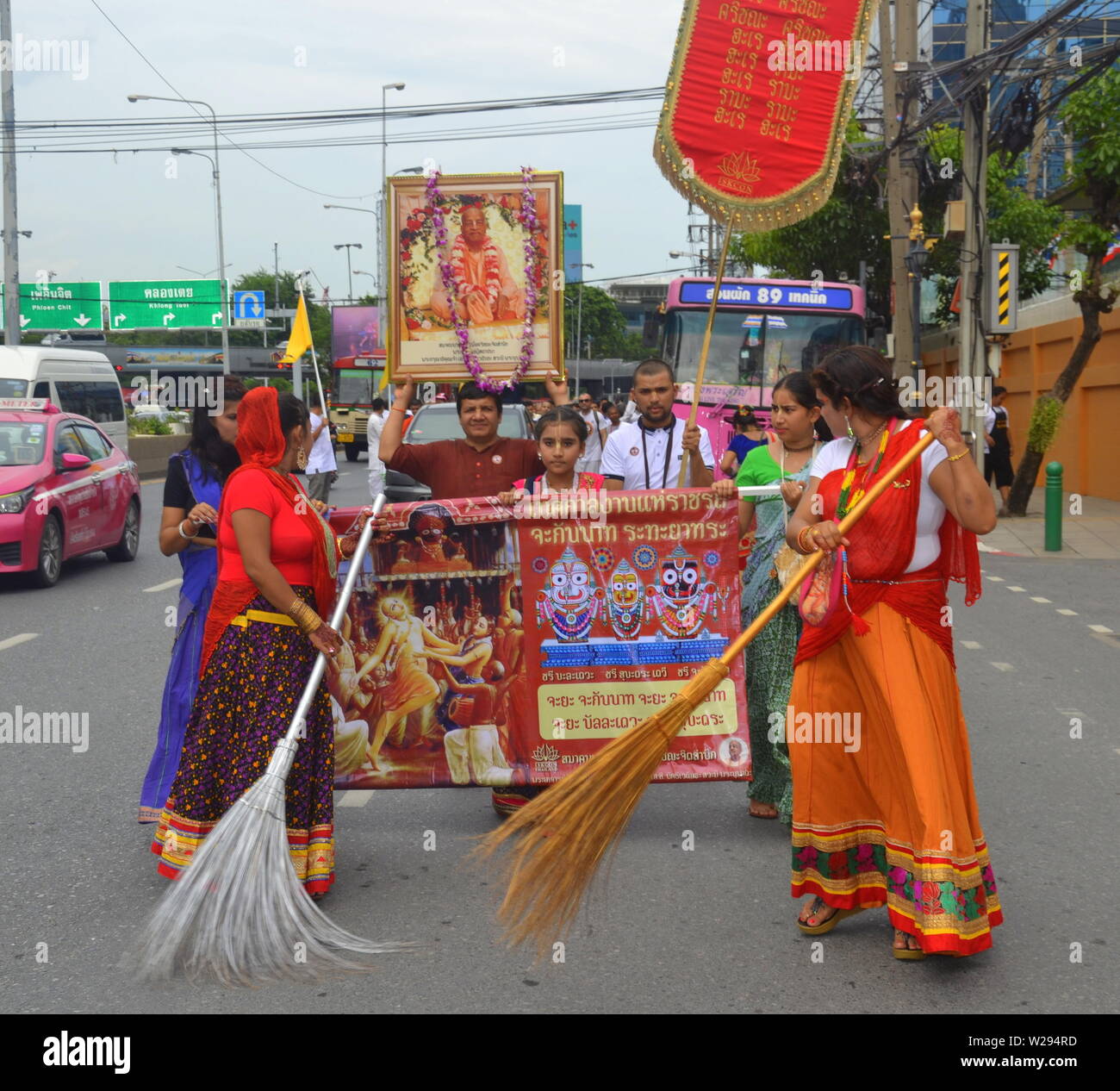 Las mujeres barrer las calles en la parte delantera de un colorido desfile por la Sociedad Internacional para la Conciencia de Krishna (ISKCON) en Bangkok, Tailandia, el 7 de julio de 2019. El desfile comenzó en la Cámara de Comercio de Indias en Sathorn Soi 1 y siguió por la calle Sathorn Road. El movimiento Hare Krishna o hare krishnas, es una organización religiosa hindú Vaishnava Gaudiya fundada en 1966 en la Ciudad de Nueva York por A. C. Bhaktivedanta Swami Prabhupada, el gurú y maestro espiritual de la organización. Foto de stock