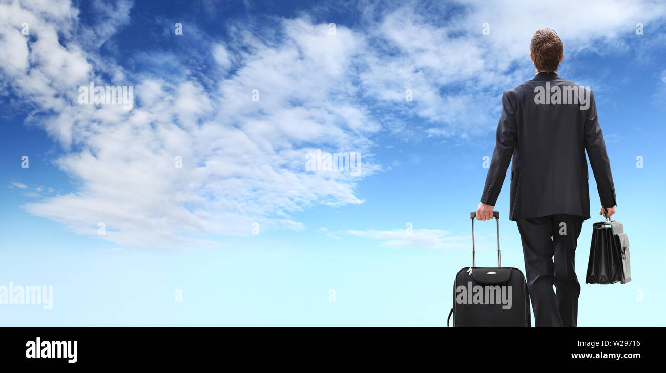 Los viajes internacionales, el concepto de hombre de negocios éxito, empresario vista caminando con el carro y el maletín, aislado sobre fondo de cielo azul stock - Alamy
