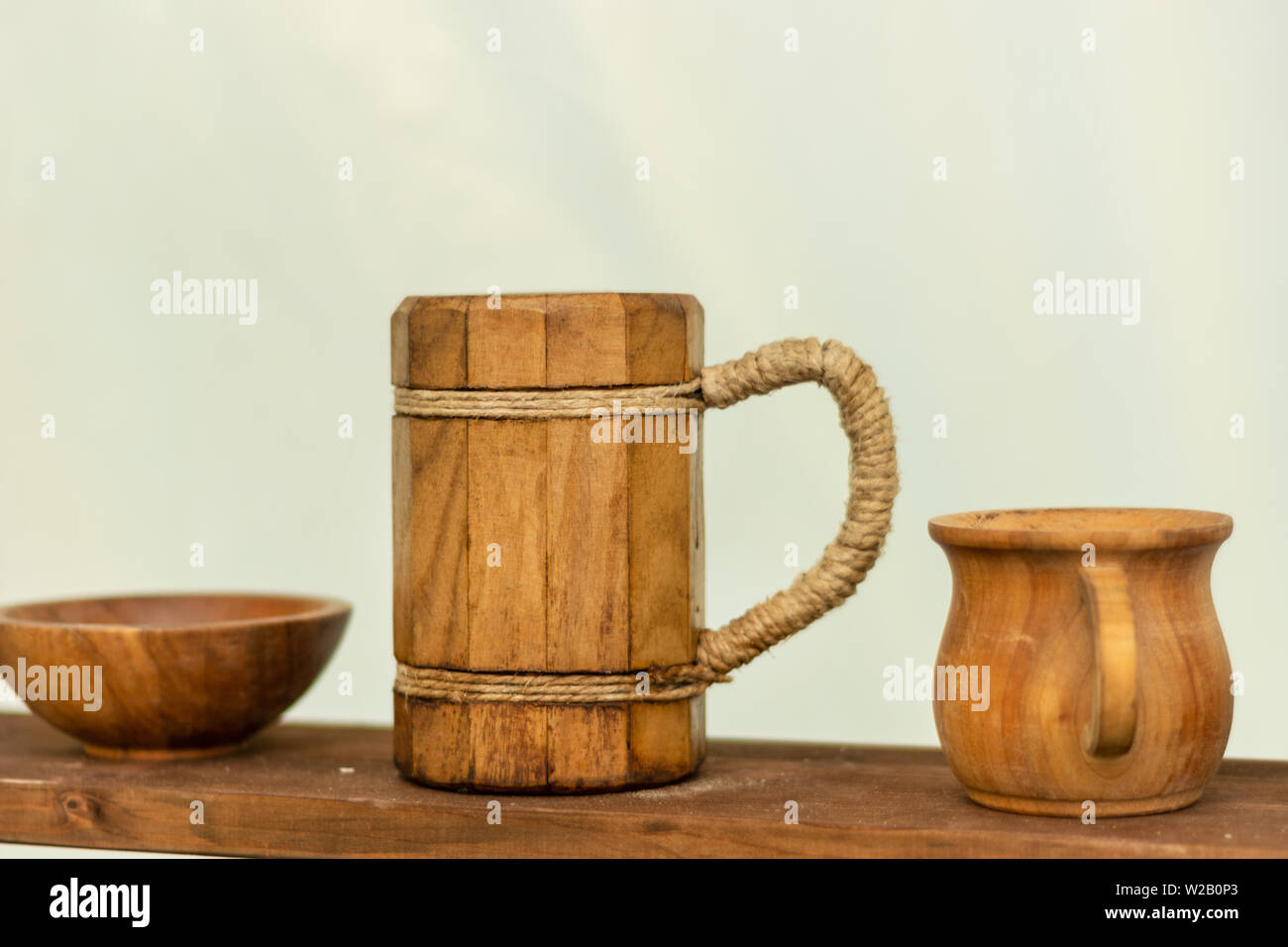 Jarra de cerveza de madera medievales en el estante de madera. Muy antiguos  utensilios de madera y cuencos para agua o alcohol bebidas y alimentos.  Cerca, el enfoque selectivo Fotografía de stock -