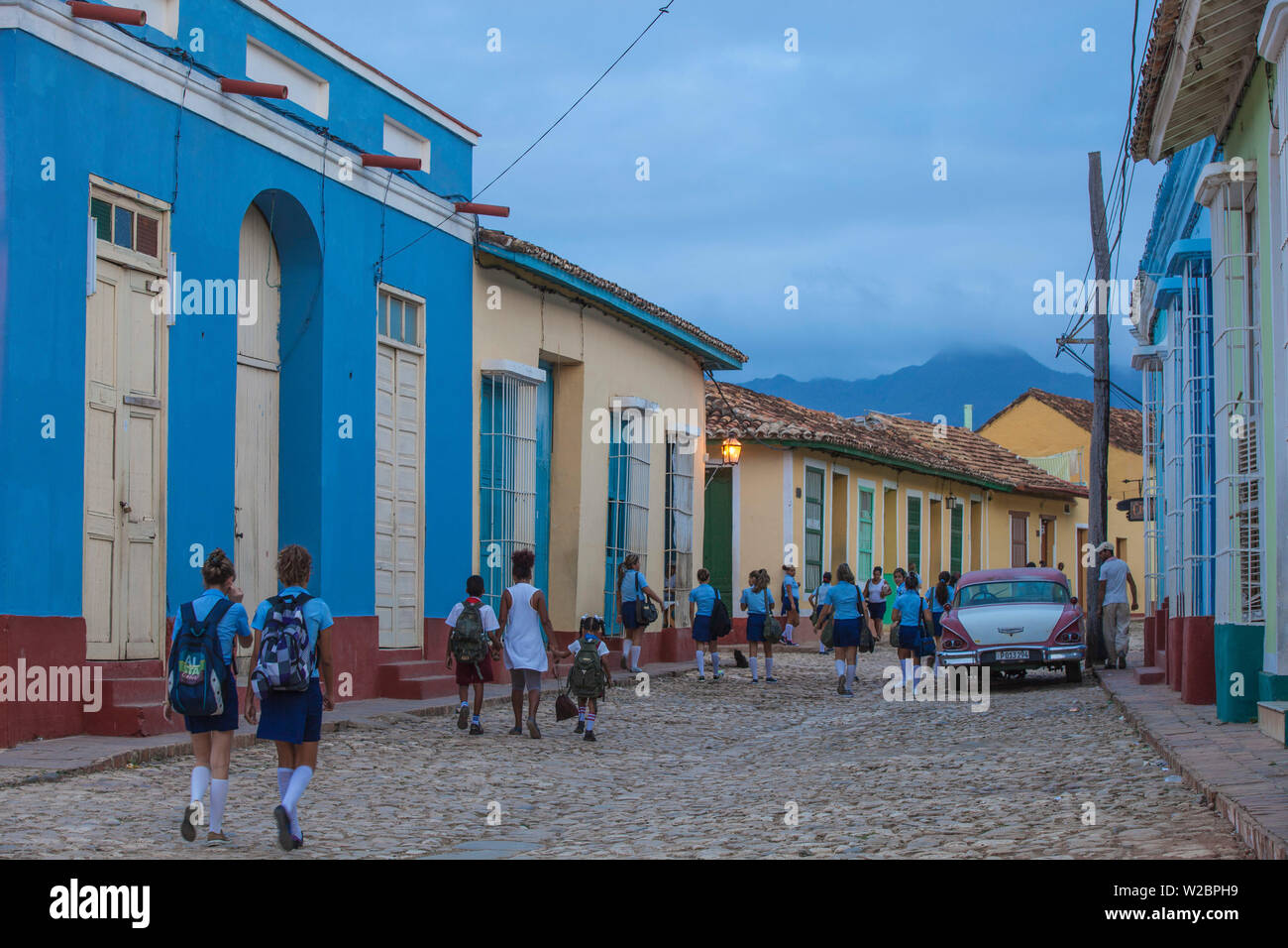 Cuba, Trinidad, niños caminando por coche clásico americano en camino a la escuela Foto de stock