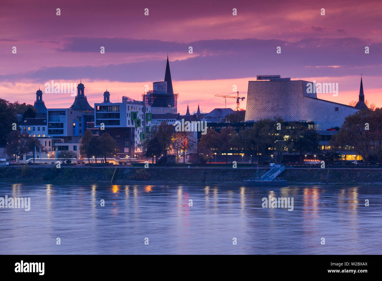 Alemania, Nordrhein-Westfalen, Bonn, Rhein Riverfront y el edificio de la Ópera de Bonn, el anochecer Foto de stock