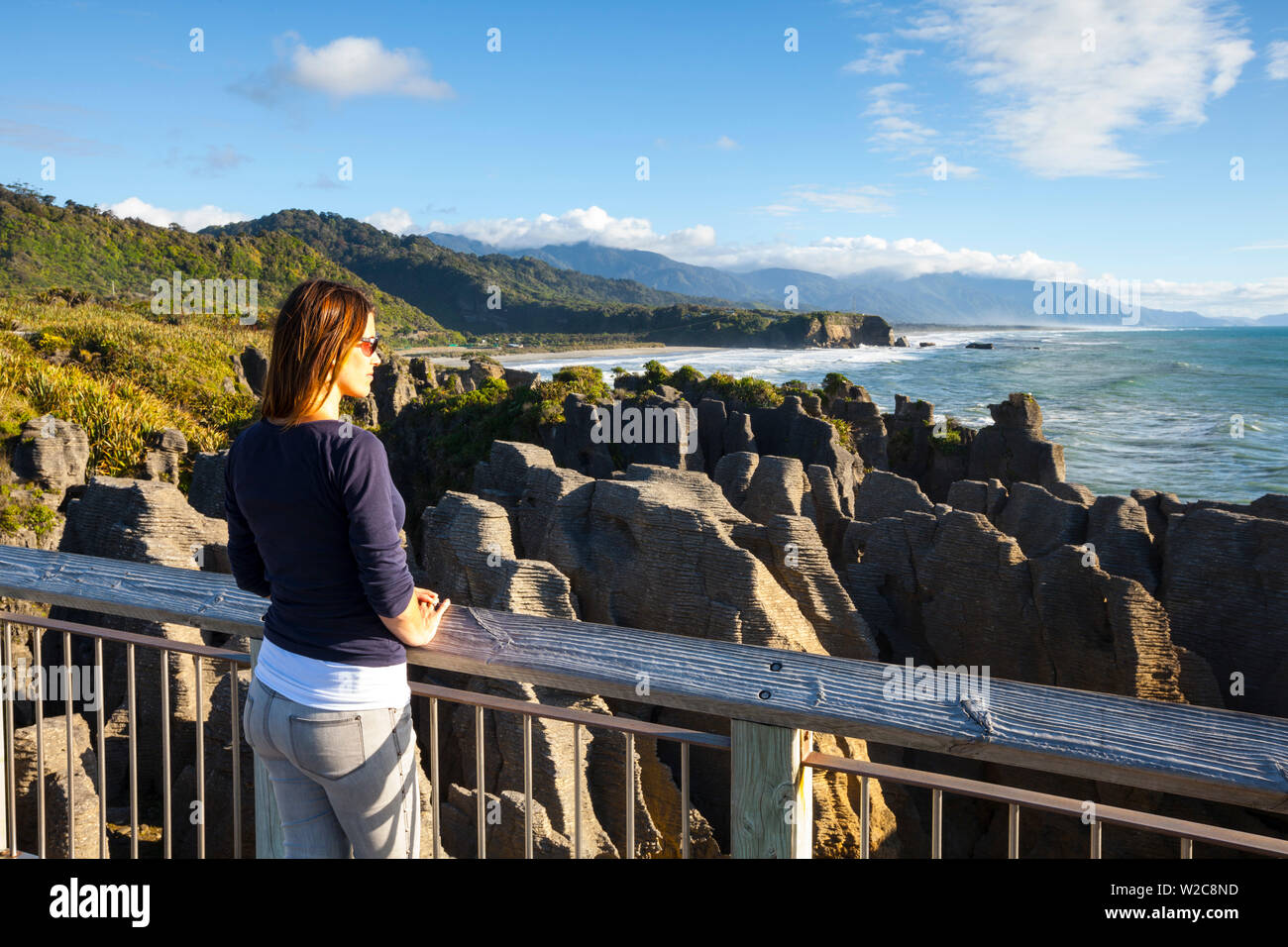 Un turista vistas las dramáticas formaciones de piedra caliza, en Punakaiki, Costa oeste, Isla del Sur, Nueva Zelanda Foto de stock