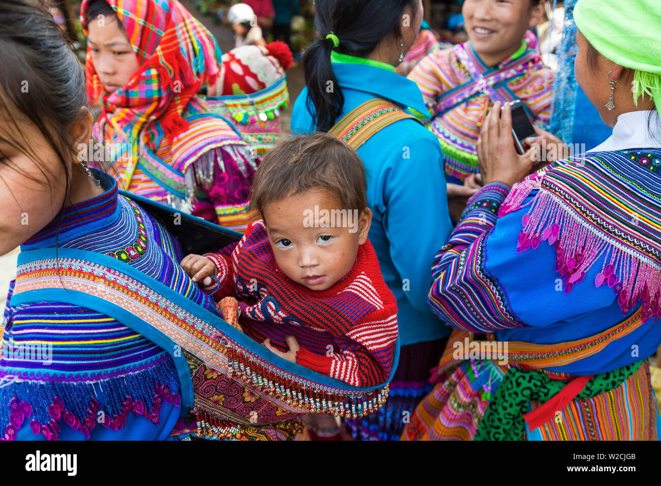 Bebé de madres, Flor de la tribu Hmong, mercado de Bac Ha, Vietnam Foto de stock