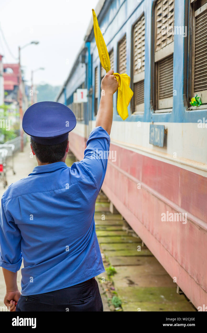 El protector con la bandera en la estación de ferrocarril, Hanoi, Vietnam Foto de stock