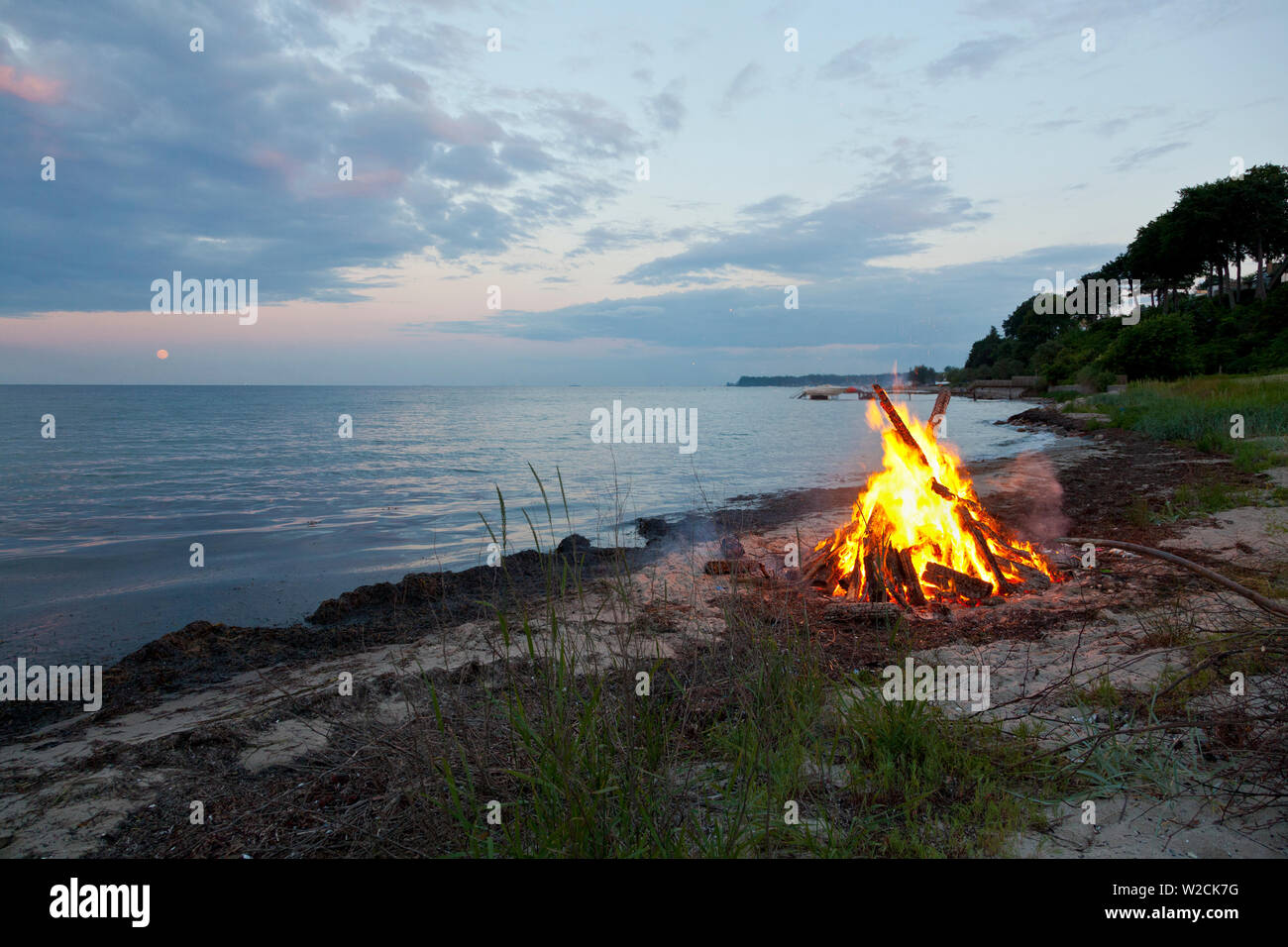 Hoguera en la luz del norte de noche de verano en la playa en Skodsborg, Sealand, Dinamarca en celebración del solsticio de verano y la víspera de San Juan, Sankthansaften Foto de stock