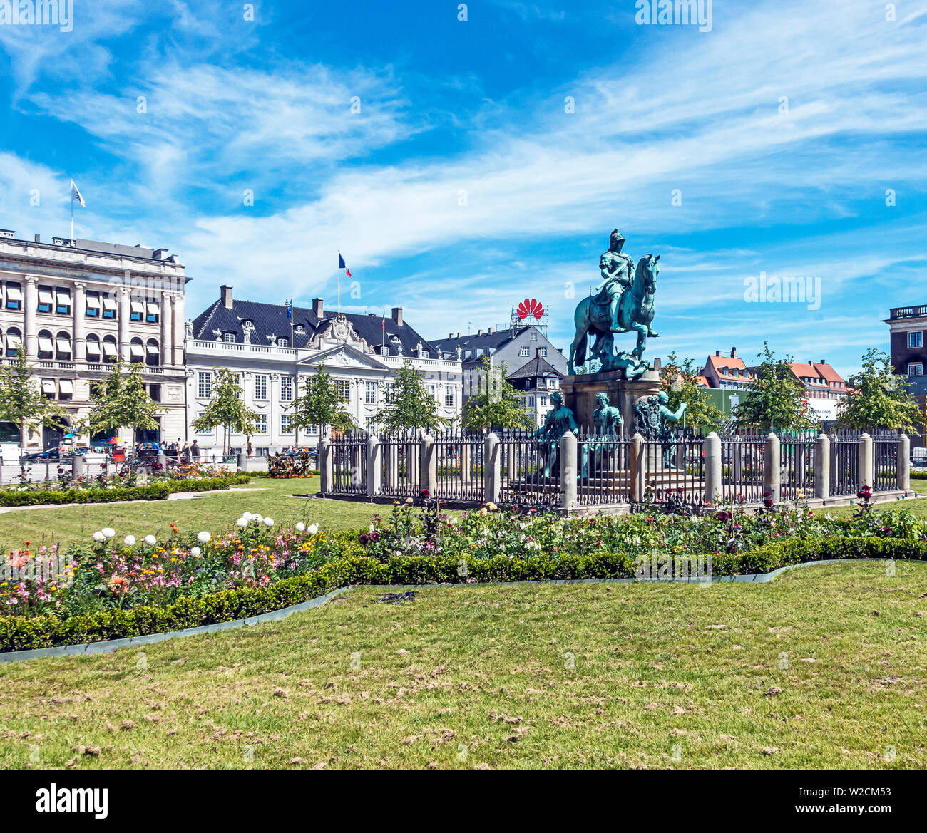 Estatua ecuestre de Christian V en el centro de Kongens Nytorv Nyhavn, Copenhague, Dinamarca con arreglos florales después de la estación de metro. Foto de stock