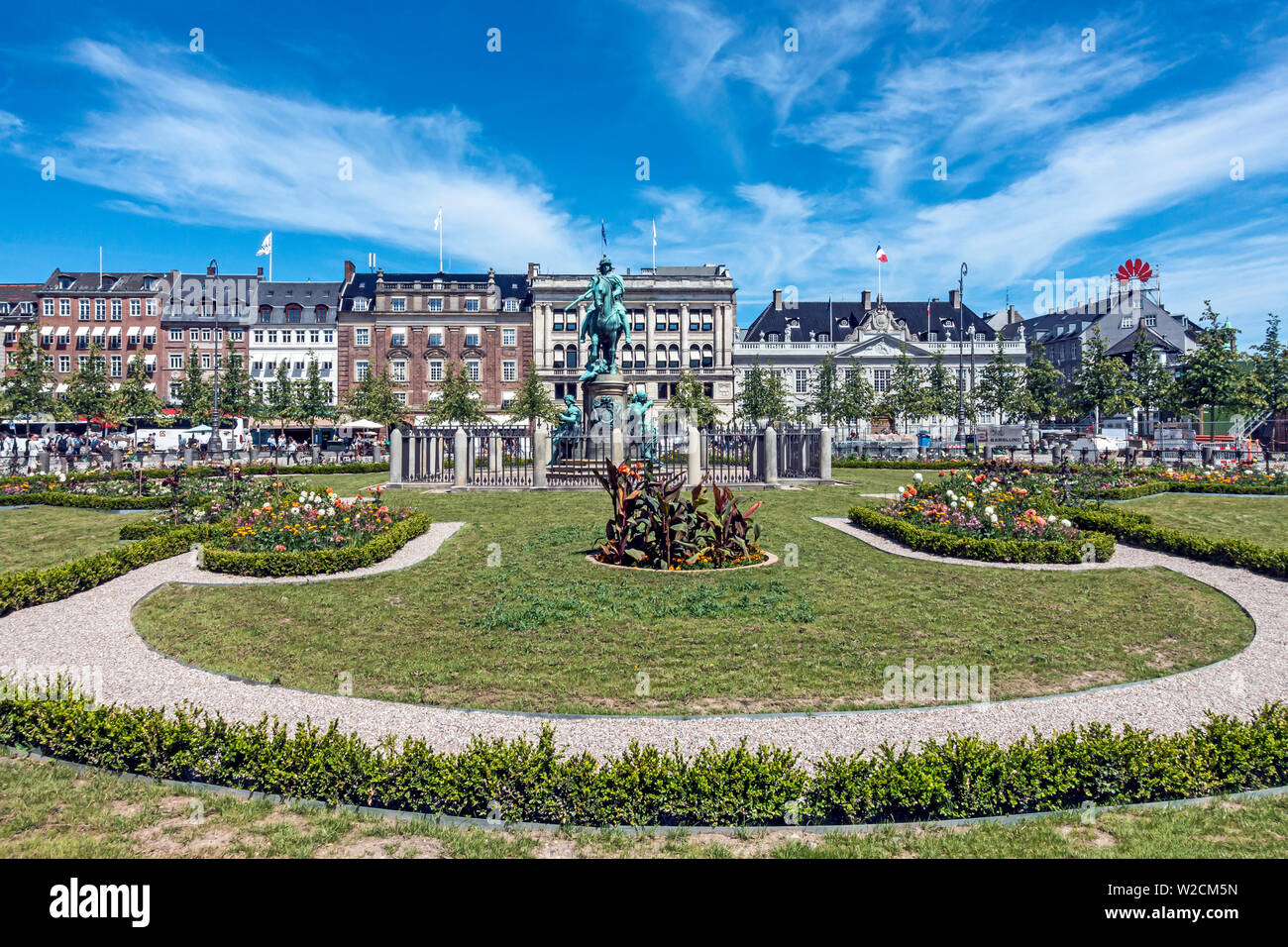 Estatua ecuestre de Christian V en el centro de Kongens Nytorv Nyhavn, Copenhague, Dinamarca con arreglos florales después de la estación de metro. Foto de stock