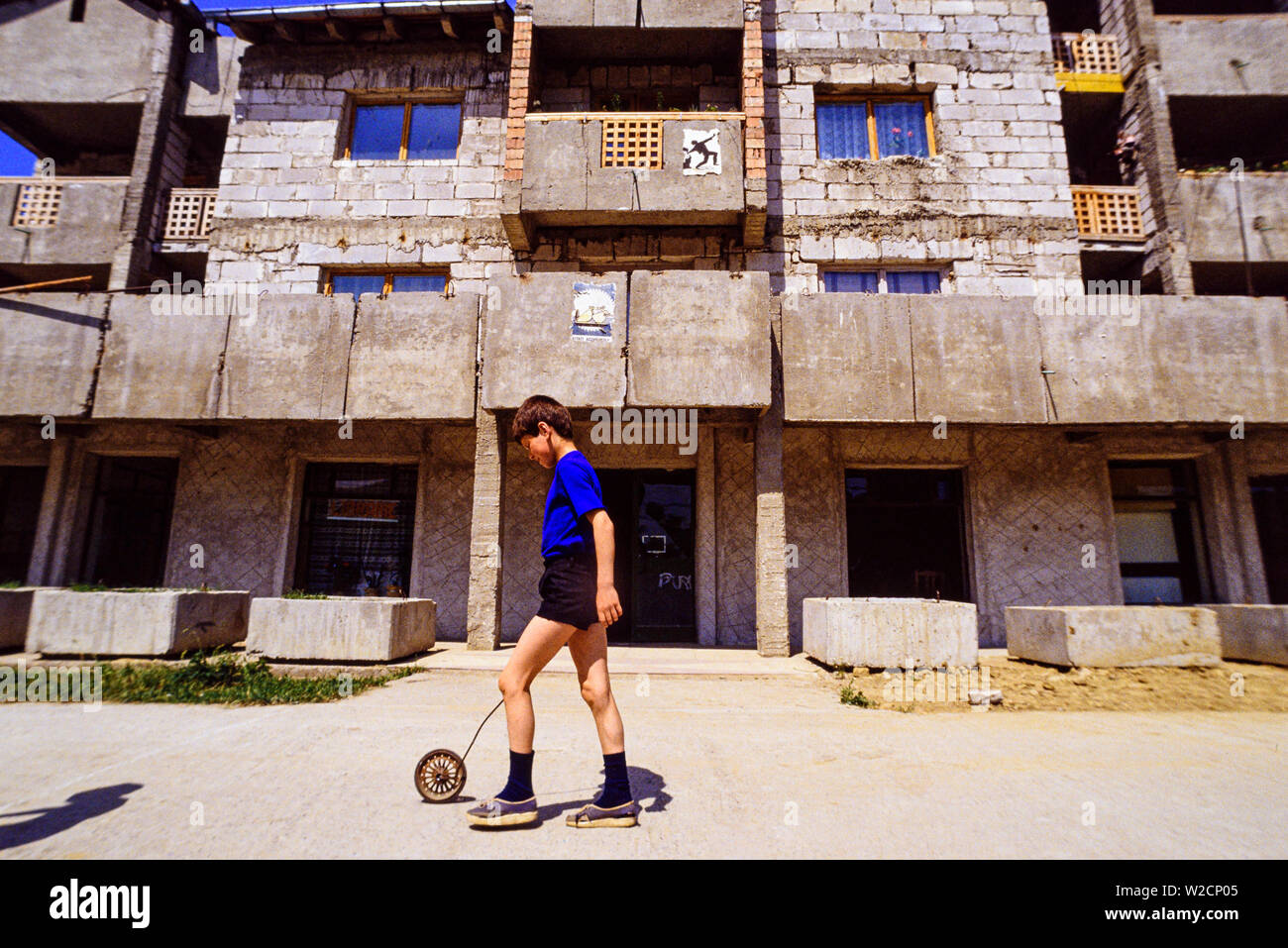 Rumania, mayo de 1990. Escenas rurales.Un joven juega delante de un edificio inacabado. Foto: © Simon Grosset. Archivo: Imagen digitalizada de una transparencia original. Foto de stock