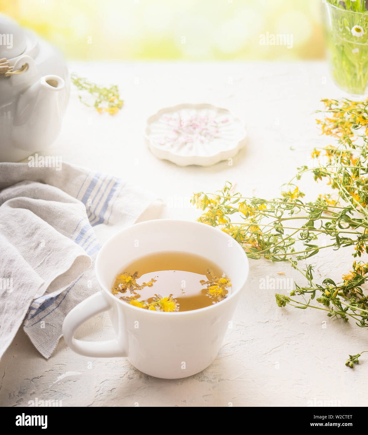 Taza de té de hierbas en el cuadro blanco en un día soleado de verano de fondo. Estimular el sistema inmunitario y el sistema digestivo. Remedios naturales saludables Foto de stock