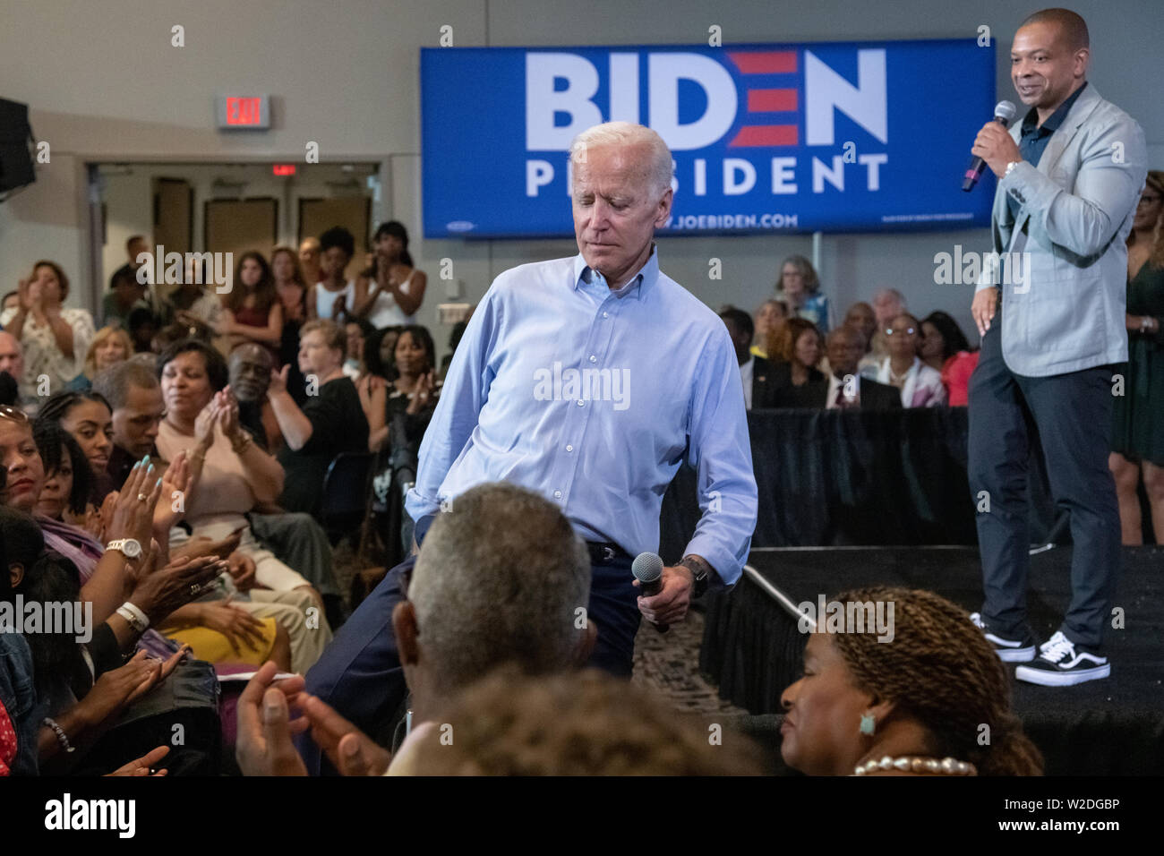 El ex vicepresidente estadounidense, Joe Biden, pasos sobre la muchedumbre barrera en la audiencia después de enterarse de que Felicia Sanders, el superviviente de la AME Church había disparado en la muchedumbre durante una reunión en el ayuntamiento en el Salón de la Asociación Internacional de estibador Julio 7, 2019 en Charleston, Carolina del Sur. Foto de stock