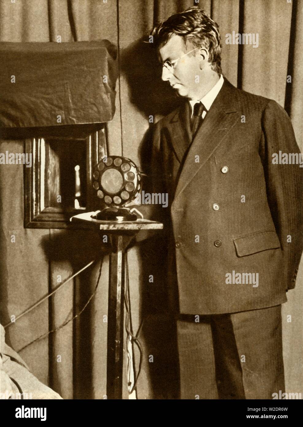 John Logie Baird viendo el primer juego a ser televisados, 14 de julio de 1930, (1935). Creador: Desconocido. Foto de stock