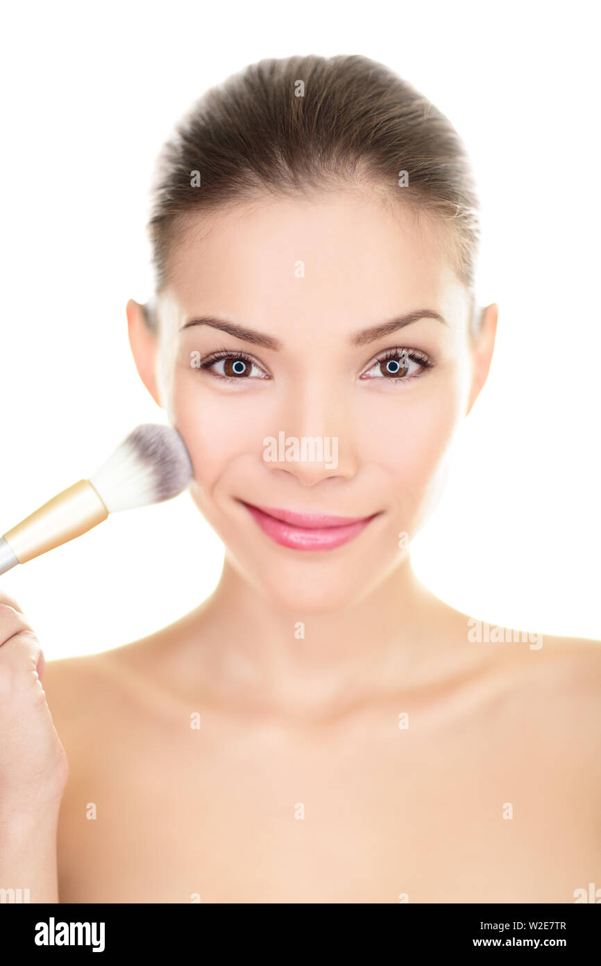 Asia belleza mujer poniendo maquillaje rubor en la cara. China girl cosmética aplicando el polvo con cepillo en mejillas closeup sonriendo ante la cámara. Raza mixta chino / modelo asiático caucásico aislado Asia belleza mujer poniendo maquillaje rubor en la cara. China girl cosmética aplicando el polvo con cepillo en mejillas closeup sonriendo ante la cámara. Raza mixta chino / modelo asiático caucásico aislado