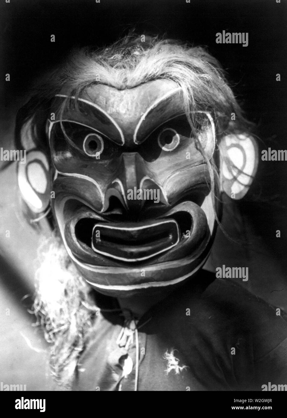 Edward S. Curits Indios Nativos Americanos - Kwakiutl persona vestida de criatura mítica Pgwis máscara (el hombre del mar) ca. 1914 Foto de stock