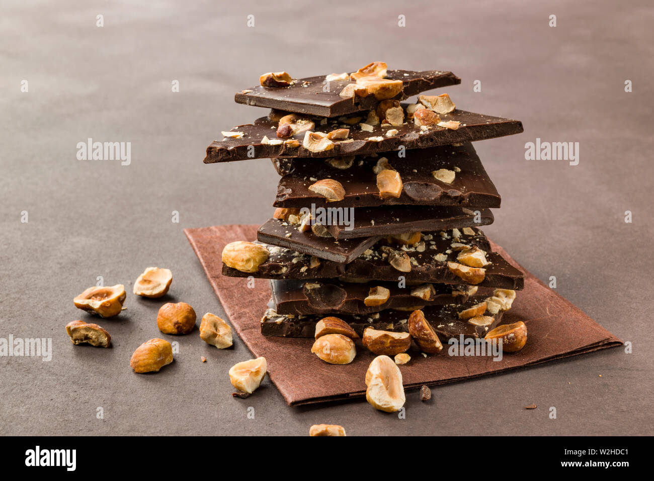Avellana trozos de chocolate oscuro sobre fondo marrón Foto de stock
