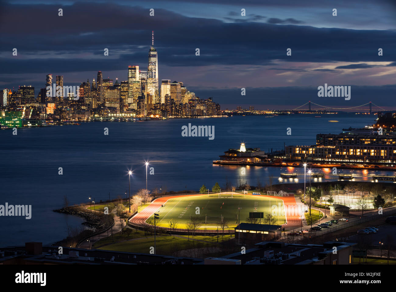 El distrito financiero de la ciudad de Nueva York rascacielos en la noche con el río Hudson y Weekhawken, Nueva Jersey Riverfront. World Trade Center, Manhattan, NY Foto de stock