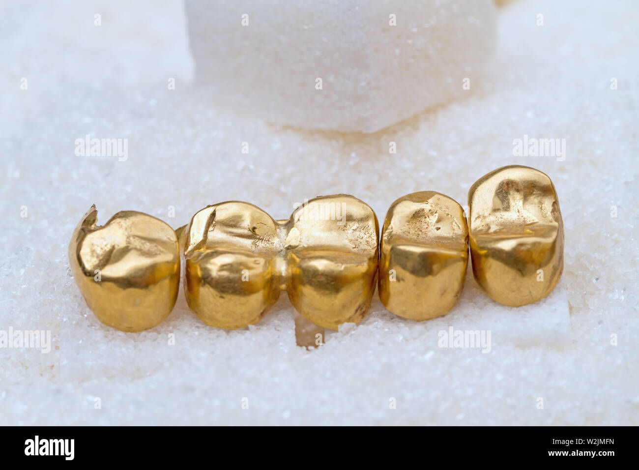 Las coronas dentales de oro (prótesis dentales) sobre el azúcar Fotografía  de stock - Alamy