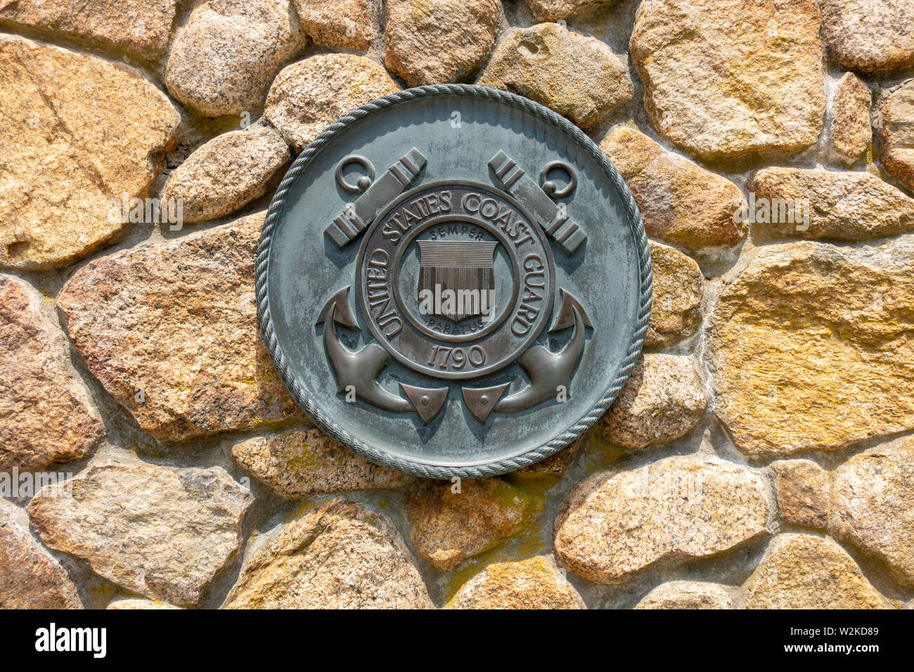 La Guardia Costera de Estados Unidos emblema de latón placa en la pared de piedra en el Cementerio Nacional de Bourne Cape Cod Massachusetts EE.UU. Foto de stock