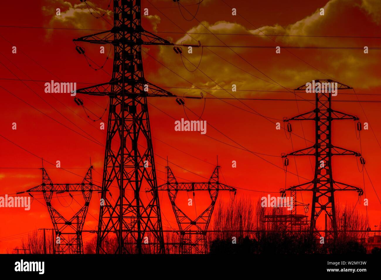 Los postes de la electricidad al atardecer, cielo naranja Foto de stock