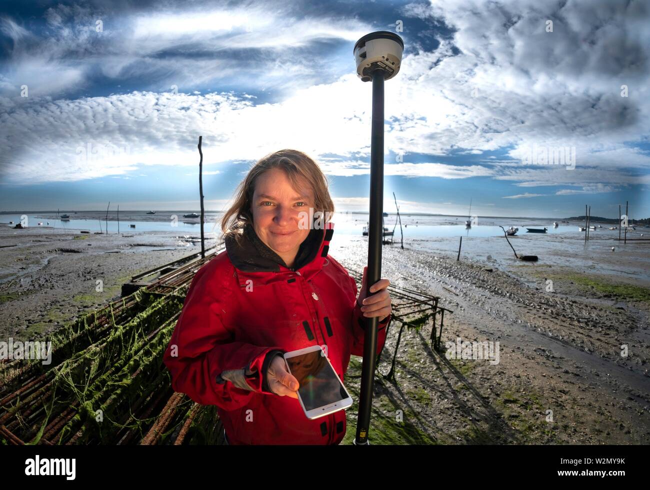 Francia, Nouvelle, Gironde Aquitania. Aurelie Dehouck, Presidente d'I-mar, toma una medición GPS en Claouey en la zona del embalse de cartografía criaderos de ostras Foto de stock