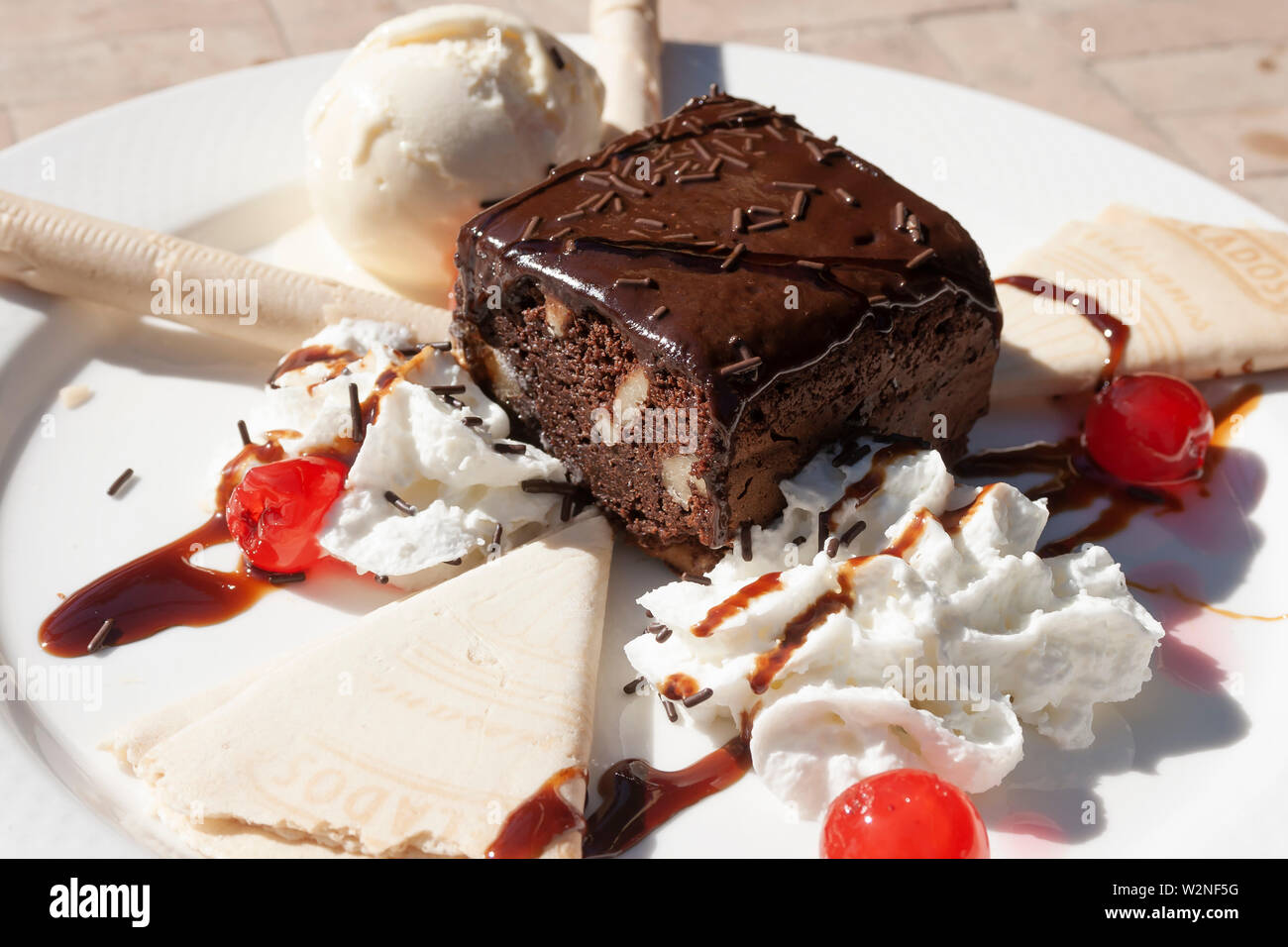 Brownie de chocolate con helado de crema y nata fresca. Foto de stock