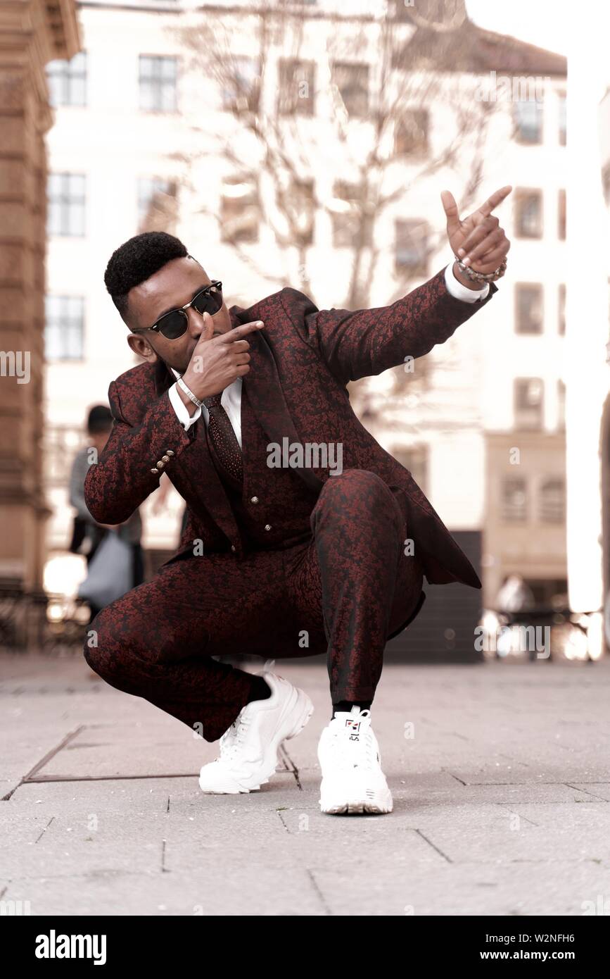Enfríe bien vestido hombre africano vistiendo elegante traje rojo en la  calle en la ciudad, celebridad, en Munich, Alemania Fotografía de stock -  Alamy