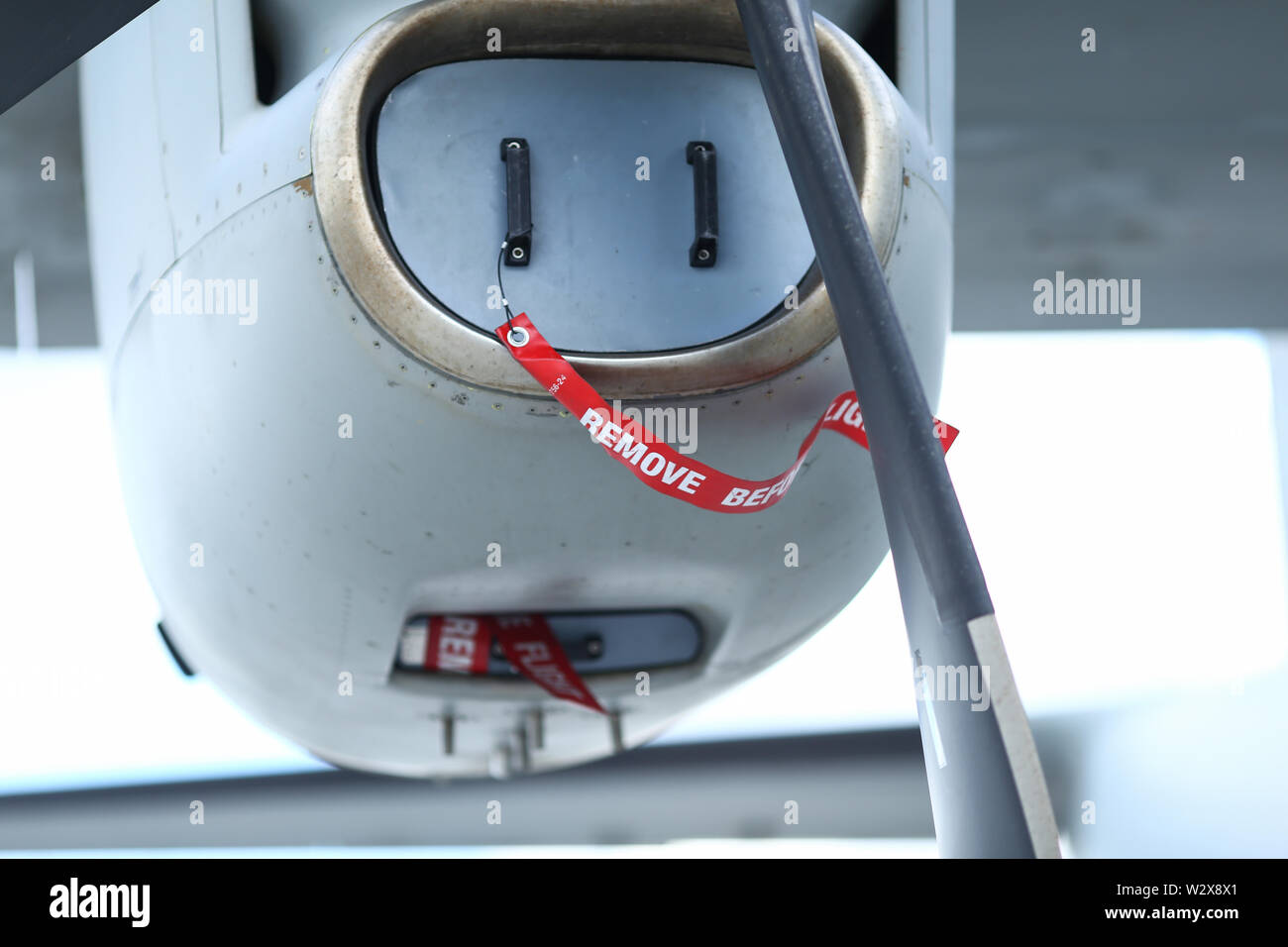 Antes de quitar la cinta de advertencia de seguridad de vuelo en la cubierta de admisión de aire del motor de un avión de carga militar Foto de stock