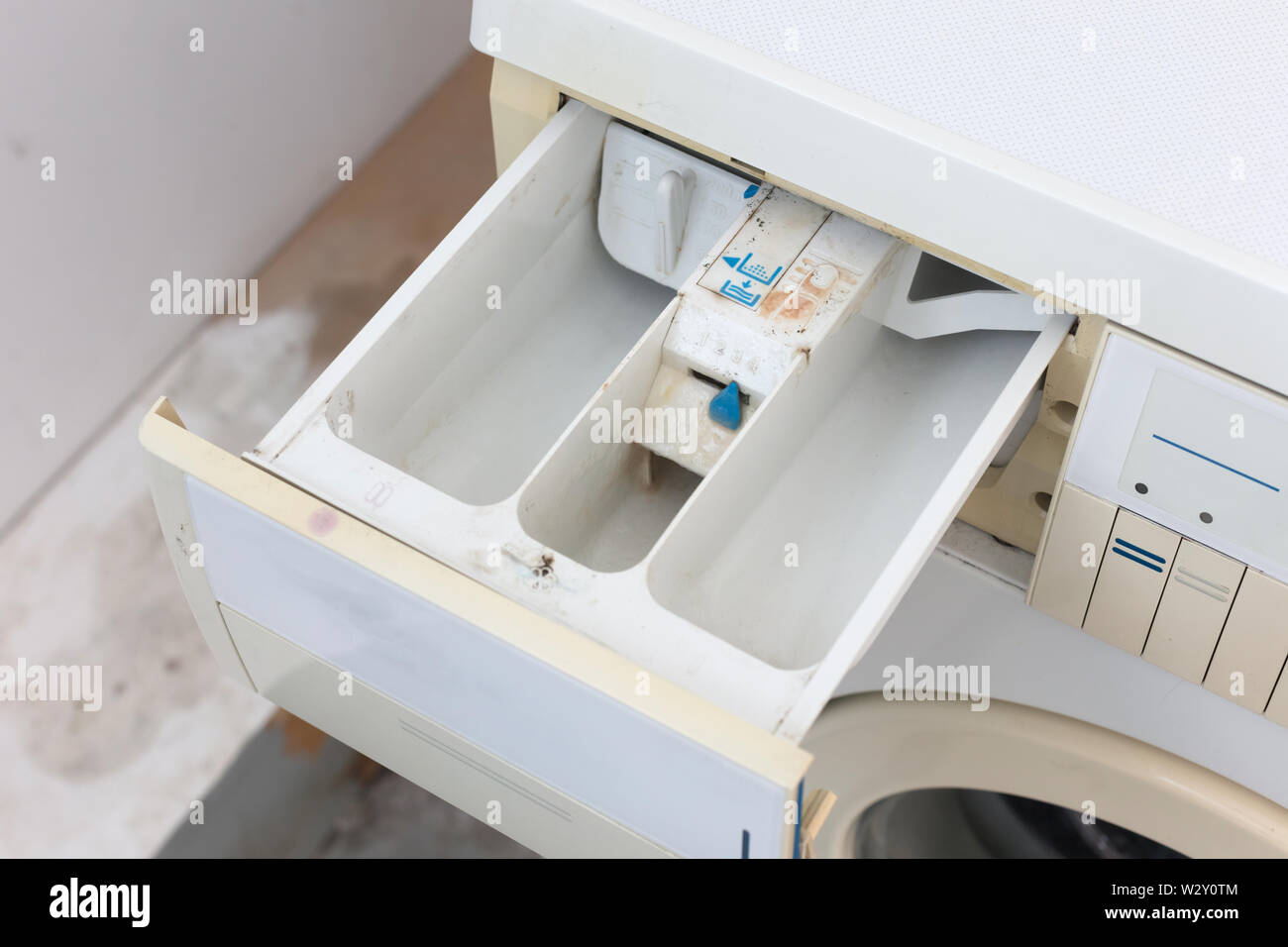 Detergente en polvo en el cajón dispensador de jabón de una lavadora de  carga frontal y un womans mano con un detergente en polvo cuchara de  medición Fotografía de stock - Alamy