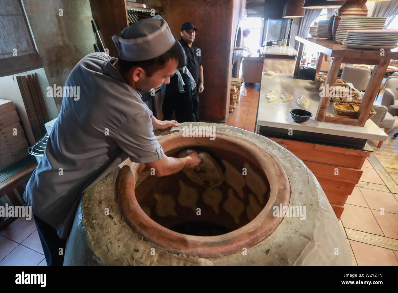 Moscú, Rusia - Julio 9, 2019: Making Adjarian khachapuri plato de pan en un horno  tandoor en el Georgian Restaurant Mama Gochi. Sergei Fadeichev/TASS  Fotografía de stock - Alamy