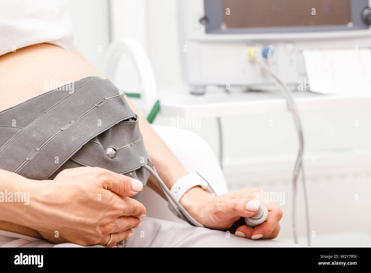 Mujer embarazada sentada en la clínica la realización de cardiotocografía  (CTG). La correa en su vientre conectado a la máquina de Toco aka Feta  electrónica Fotografía de stock - Alamy