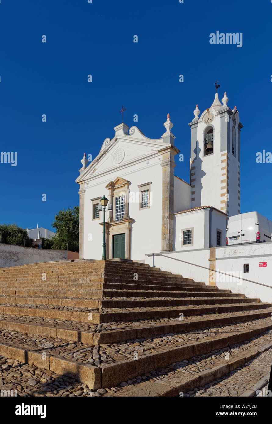 La Paropquia de São Martinho elevado en algunas terrazas pasos de adoquines en el centro de la ciudad de Estoi en el Algarve portugués, cerca de Faro. Foto de stock