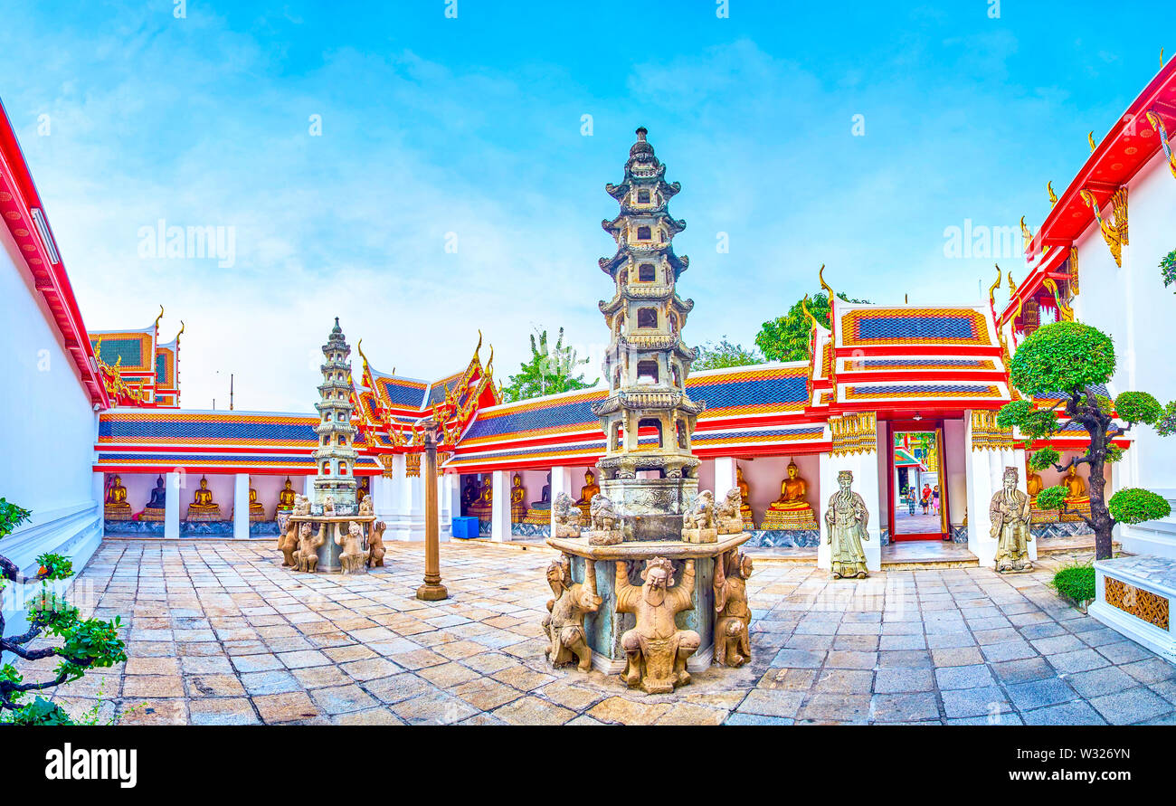 BANGKOK, TAILANDIA - Abril 22, 2019: el pequeño patio de Phra Rabiang claustro con gilden Budas en galería cubierta y dos torres de piedra en el medio, Foto de stock