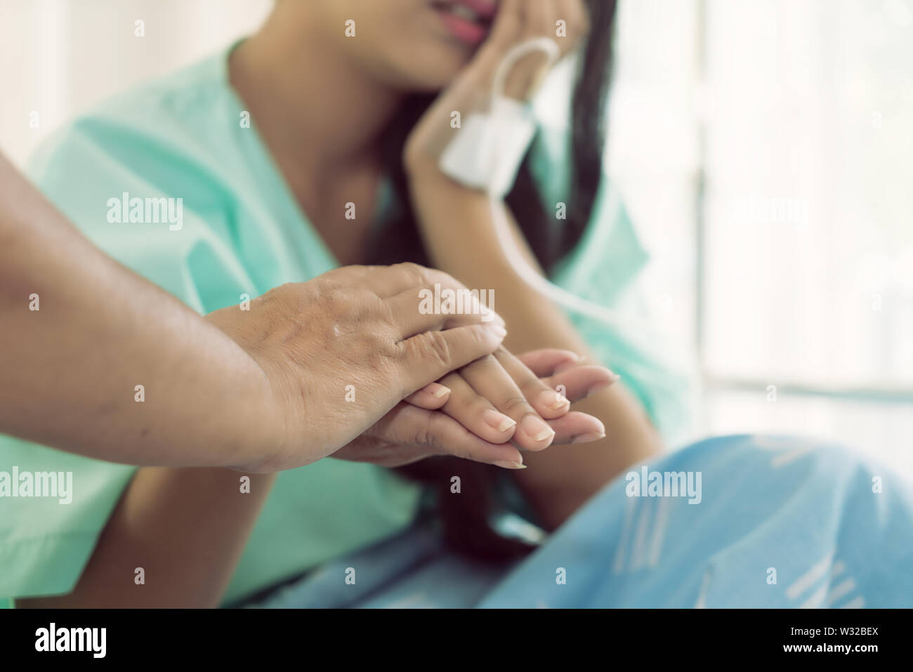 Madre manos sosteniendo su hija mano paciente sentado al escritorio de aliento, de empatía, vítores y apoyo al examen médico. Malo nuevo Foto de stock