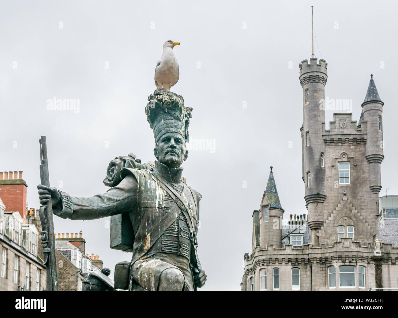 Gordon Highlanders estatua por Mark Richards, Castlegate, Aberdeen, Escocia, Reino Unido, con gull & Ciudadela edificio Foto de stock