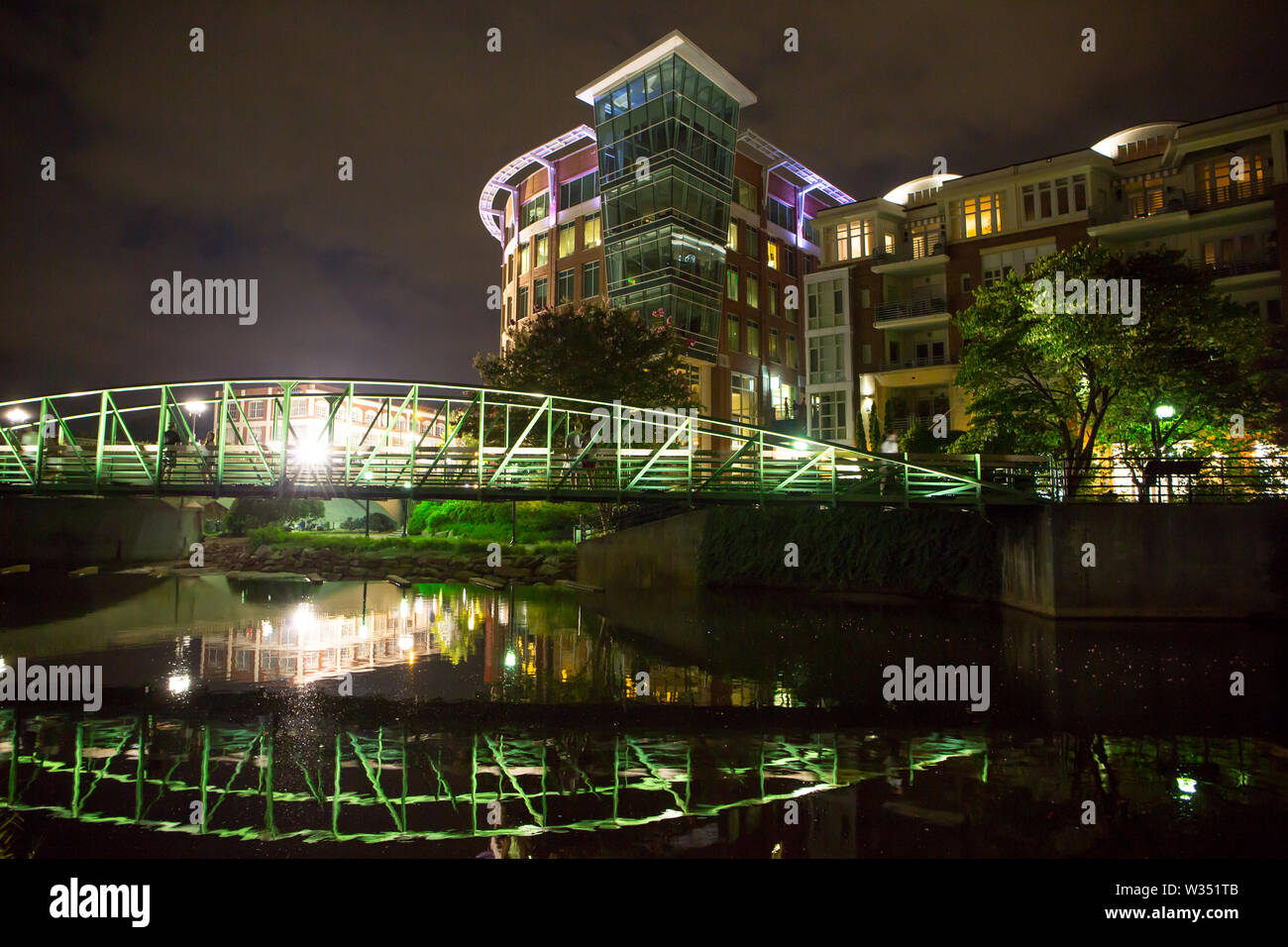 GREENVILLE, SC (USA) - Julio 5, 2019: Una vista nocturna del centro de River Walk con el río Coloque el desarrollo de hoteles, restaurantes y tiendas. Foto de stock