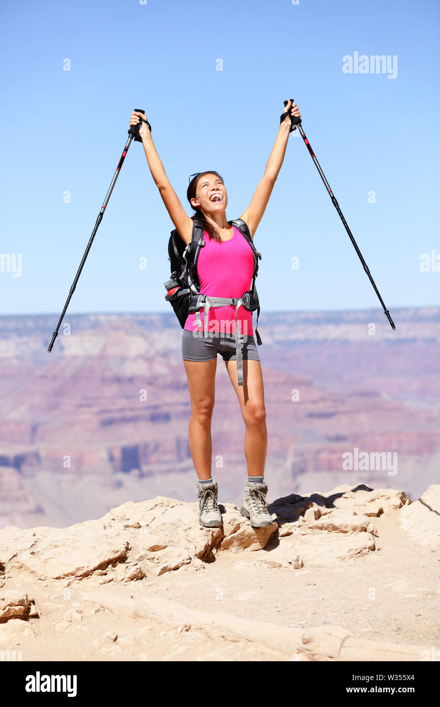 Feliz caminante por Grand Canyon aplaudiendo y celebrando con brazos levantados hacia arriba disfrutando del hermoso paisaje escénico. Senderismo mujer vistiendo una mochila y ropa exterior. en el Gran Cañón,
