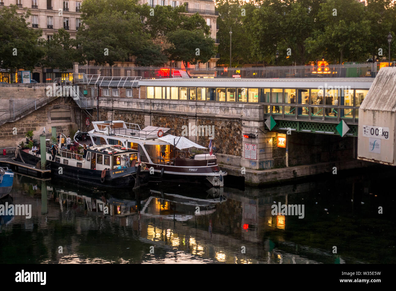Barcos y estación de metro Bastille, el Jardin du port de l'Arsenal, parque público en el Canal de St Martin, París, Francia. Foto de stock