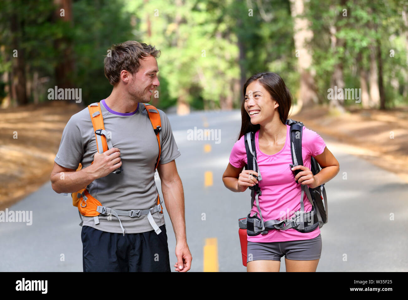Feliz pareja de excursionistas caminatas hablandonos, alegre y fresco. Pareja multirracial activa de los jóvenes en la actividad al aire libre caminata en el Parque Nacional Yosemite, California, USA. Mujer Asiática, hombre caucásico. Foto de stock