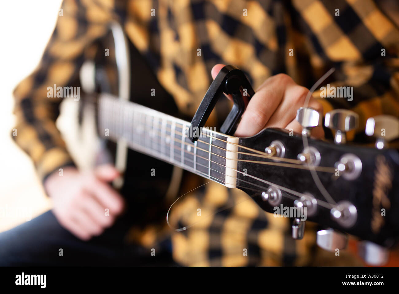 Instalar un capodaster, también llamado capo, para guitarra, poner a través  de las cuerdas. Closeup Fotografía de stock - Alamy