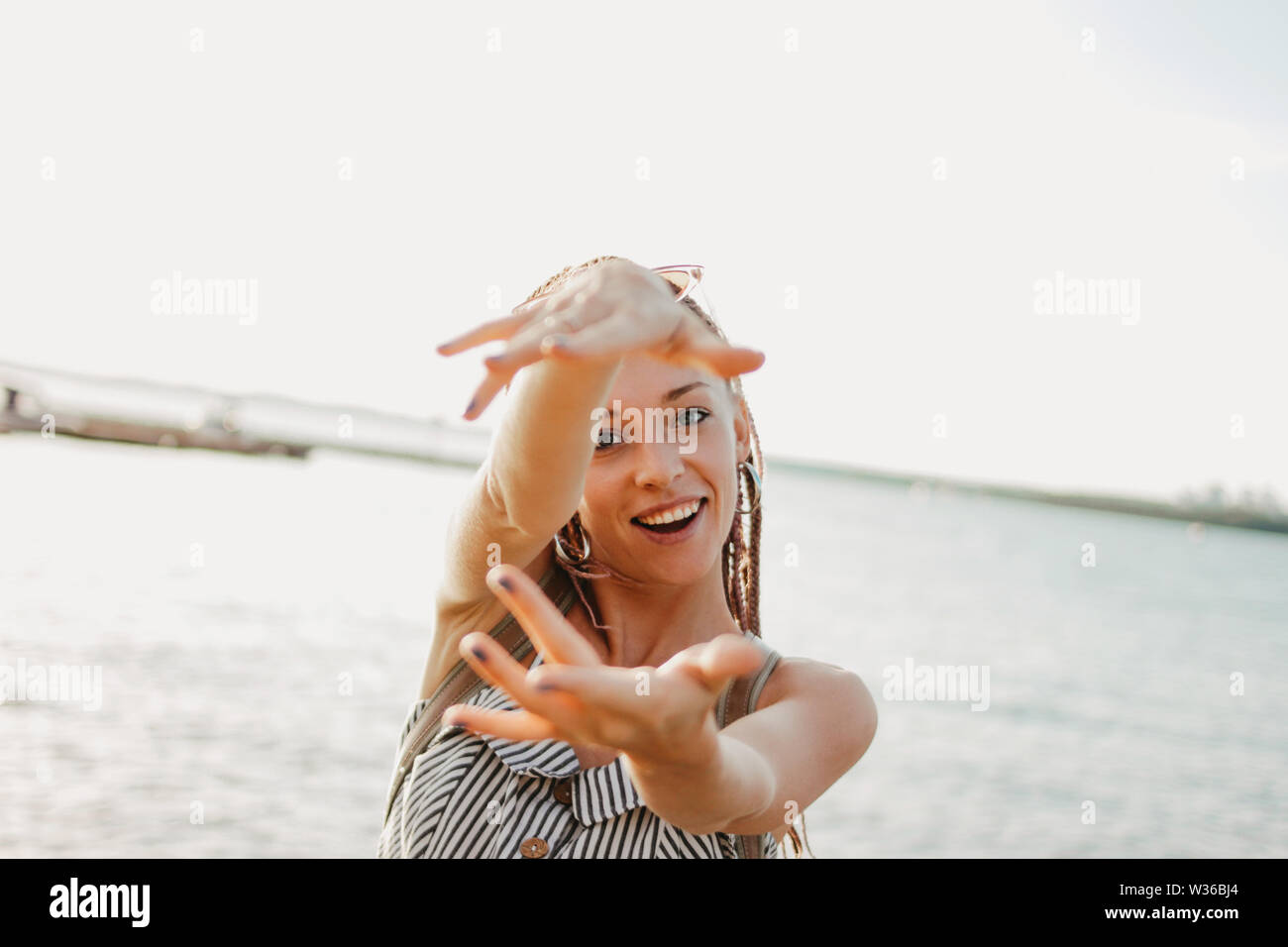 Feliz joven despreocupado con trenzas africanos disfrutan de su vida en la playa, el tiempo de vacaciones de verano Foto de stock