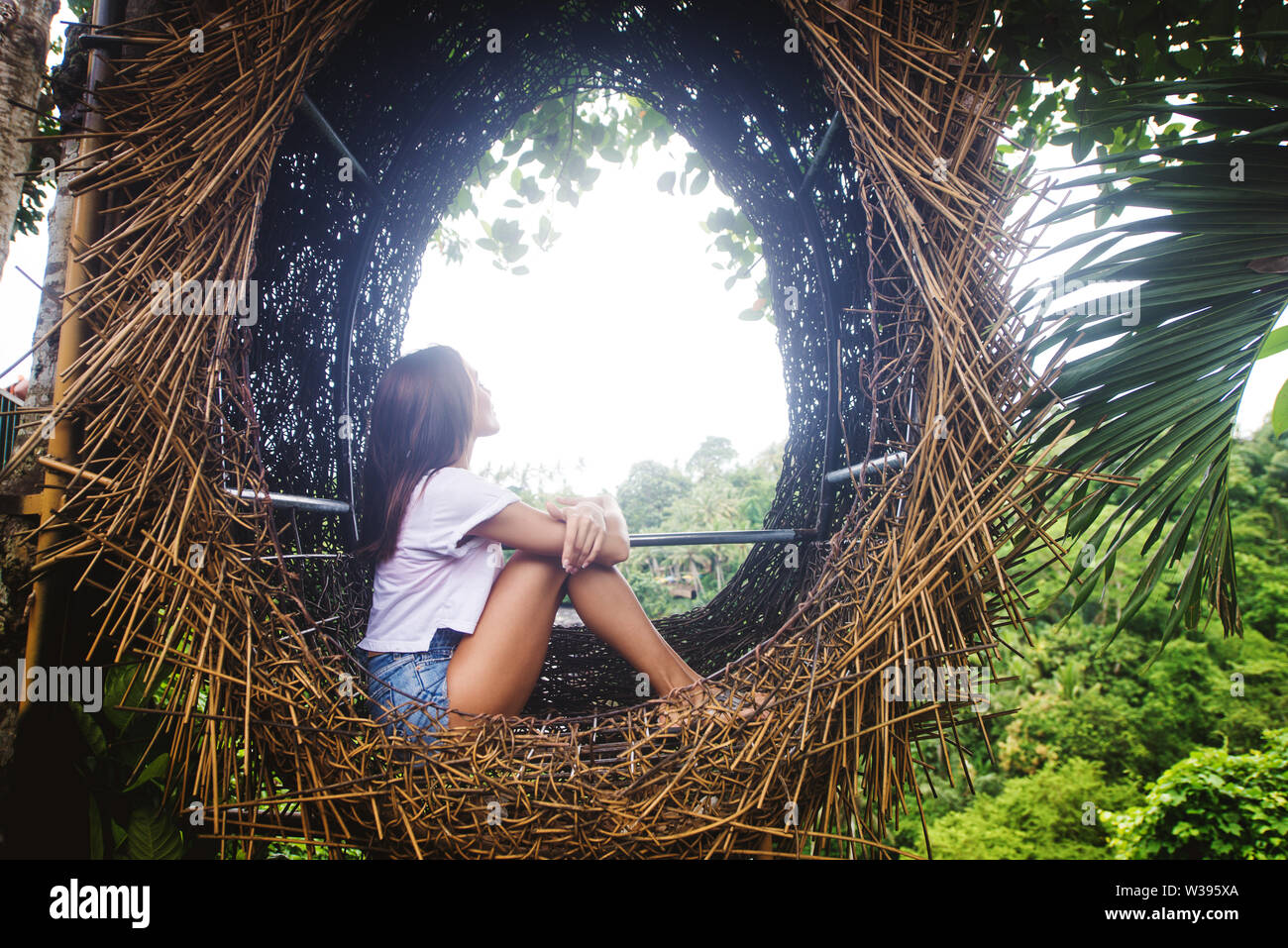 Hermosa niña en nido decorativo de la selva de la isla de Bali, Indonesia Foto de stock