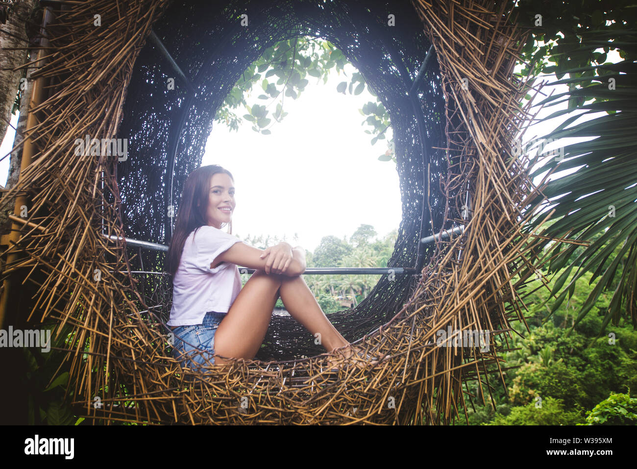 Hermosa niña en nido decorativo de la selva de la isla de Bali, Indonesia Foto de stock