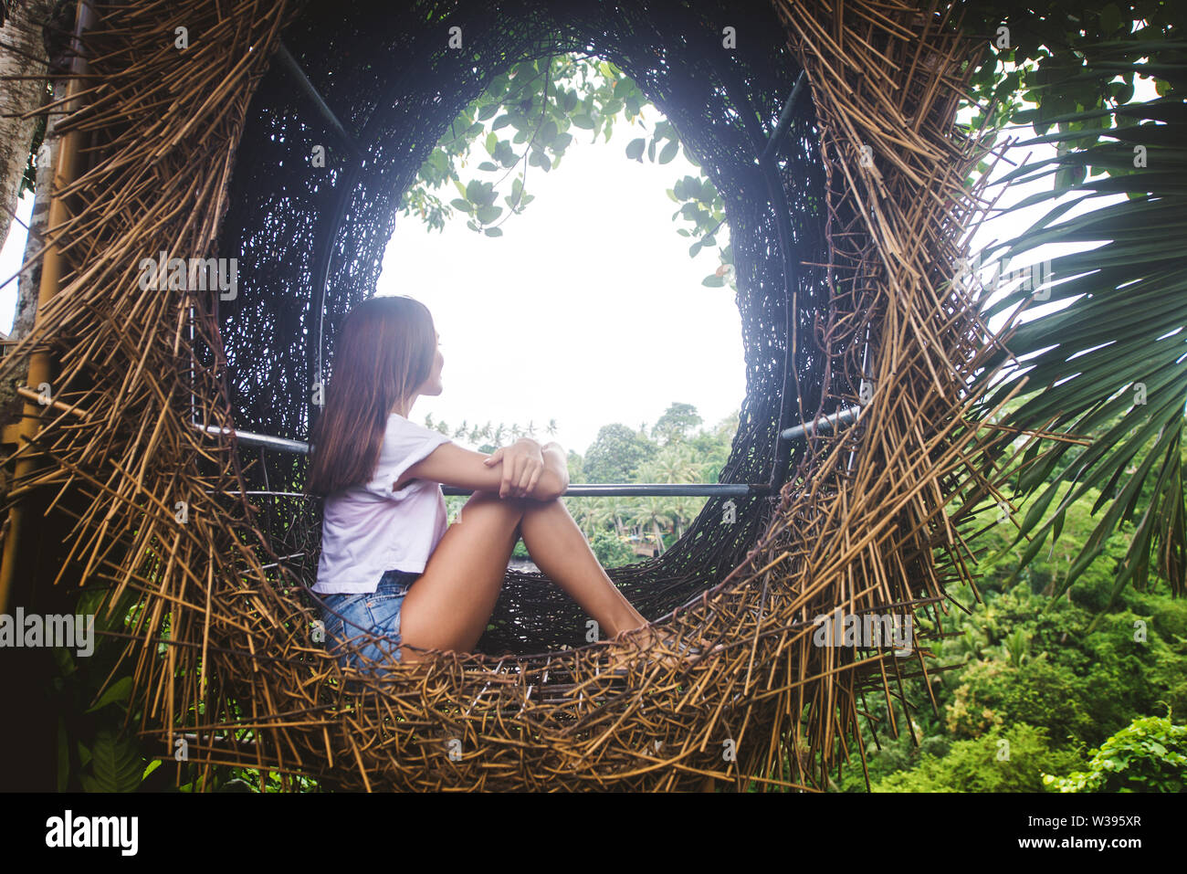 Hermosa niña en nido decorativo de la selva de la isla de Bali, Indonesia Foto de stock