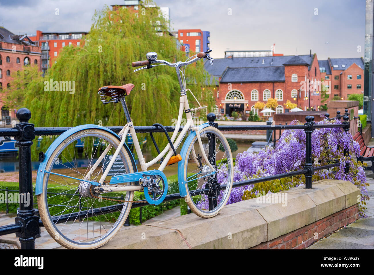 Manchester, Reino Unido - 25 de abril de 2019: Escena atmosférica de una bicicleta estacionada en el sistema de canal Victoriano restaurado en área de Castlefield Manc Foto de stock
