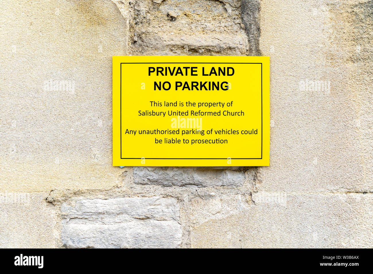 No hay aparcamiento de tierras privadas flyer fija a la pared de piedra Foto de stock