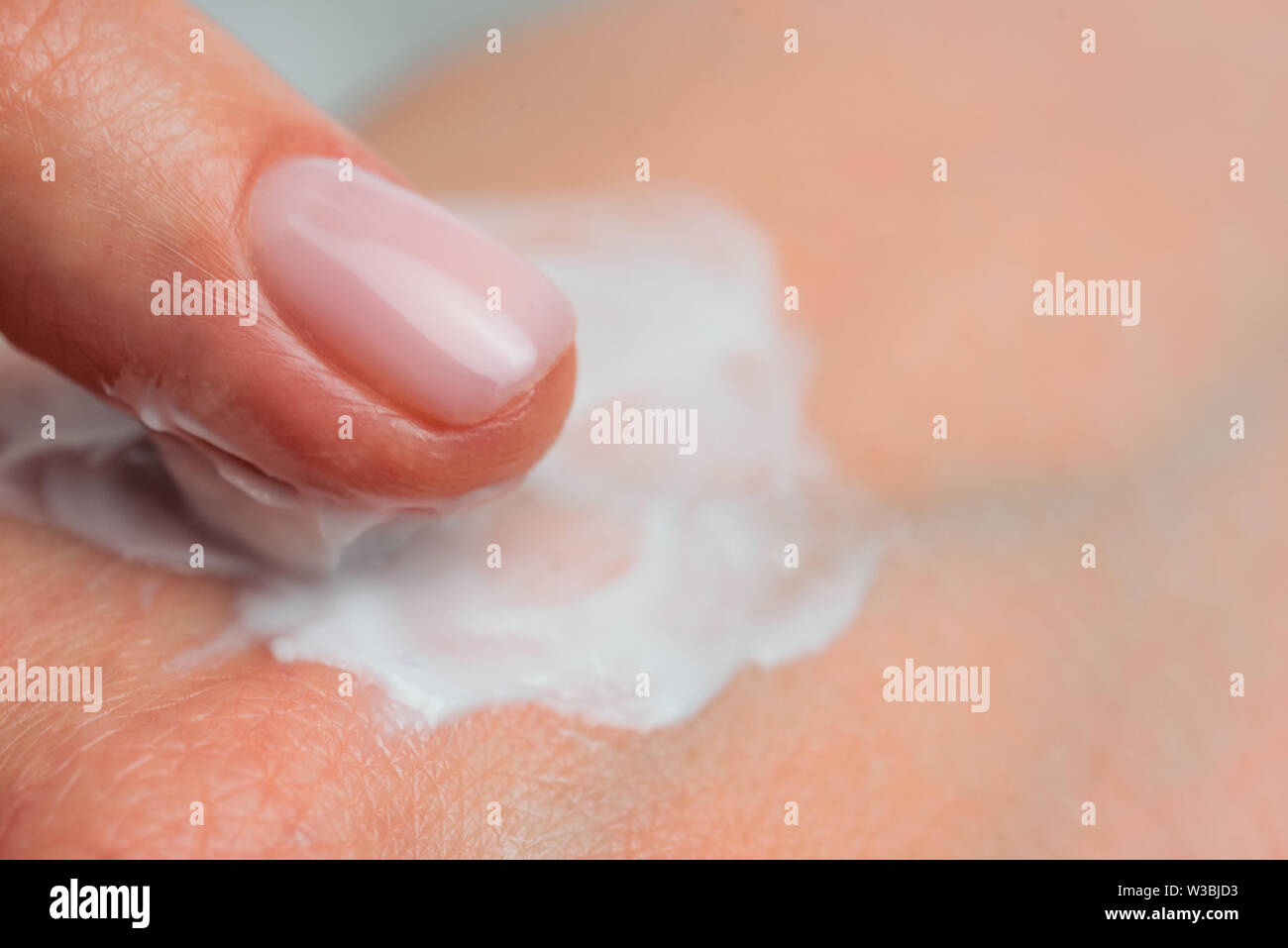 Los dedos aplicar crema para la piel. Cerrar Foto de stock