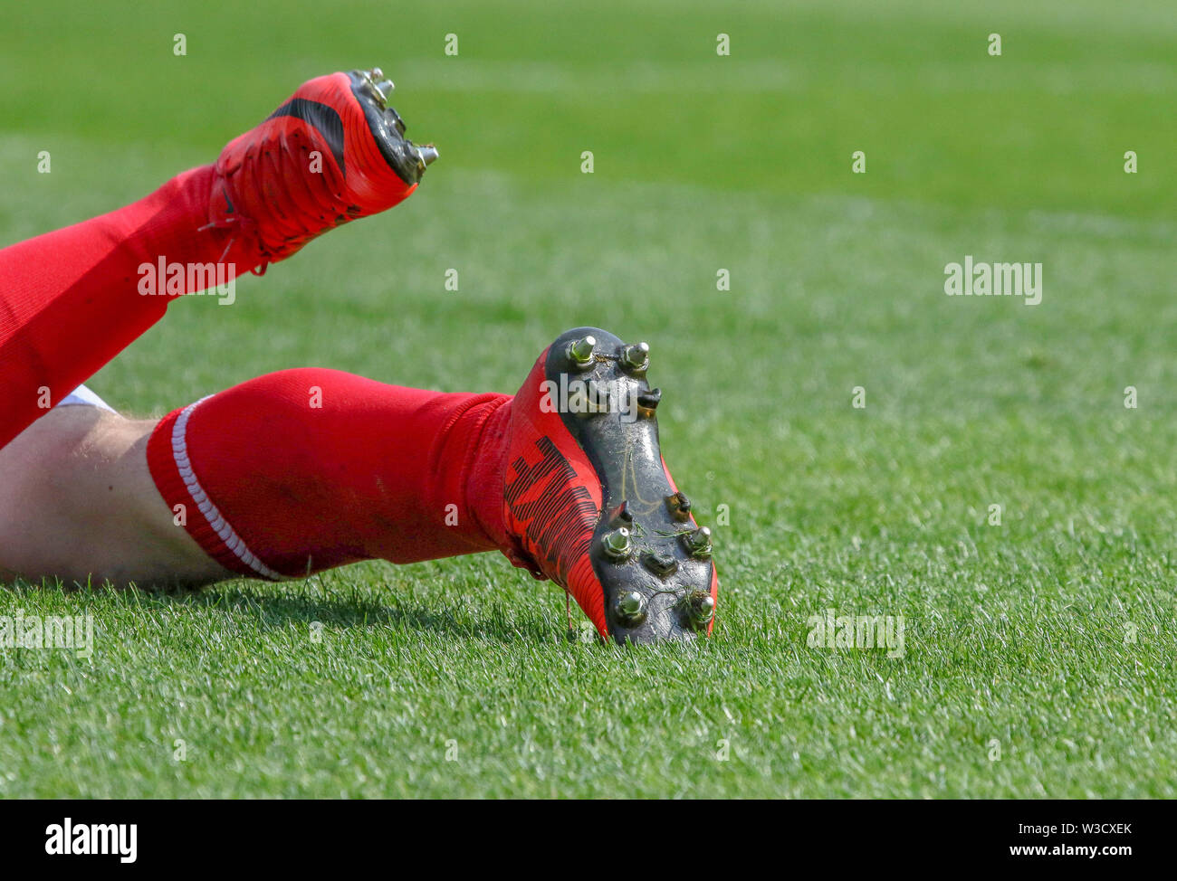 Jugador de fútbol vistiendo calcetines rojos y botas rojas tumbado sobre el  césped de fútbol después de ser intercambiadas. Sólo para uso editorial  Fotografía de stock - Alamy
