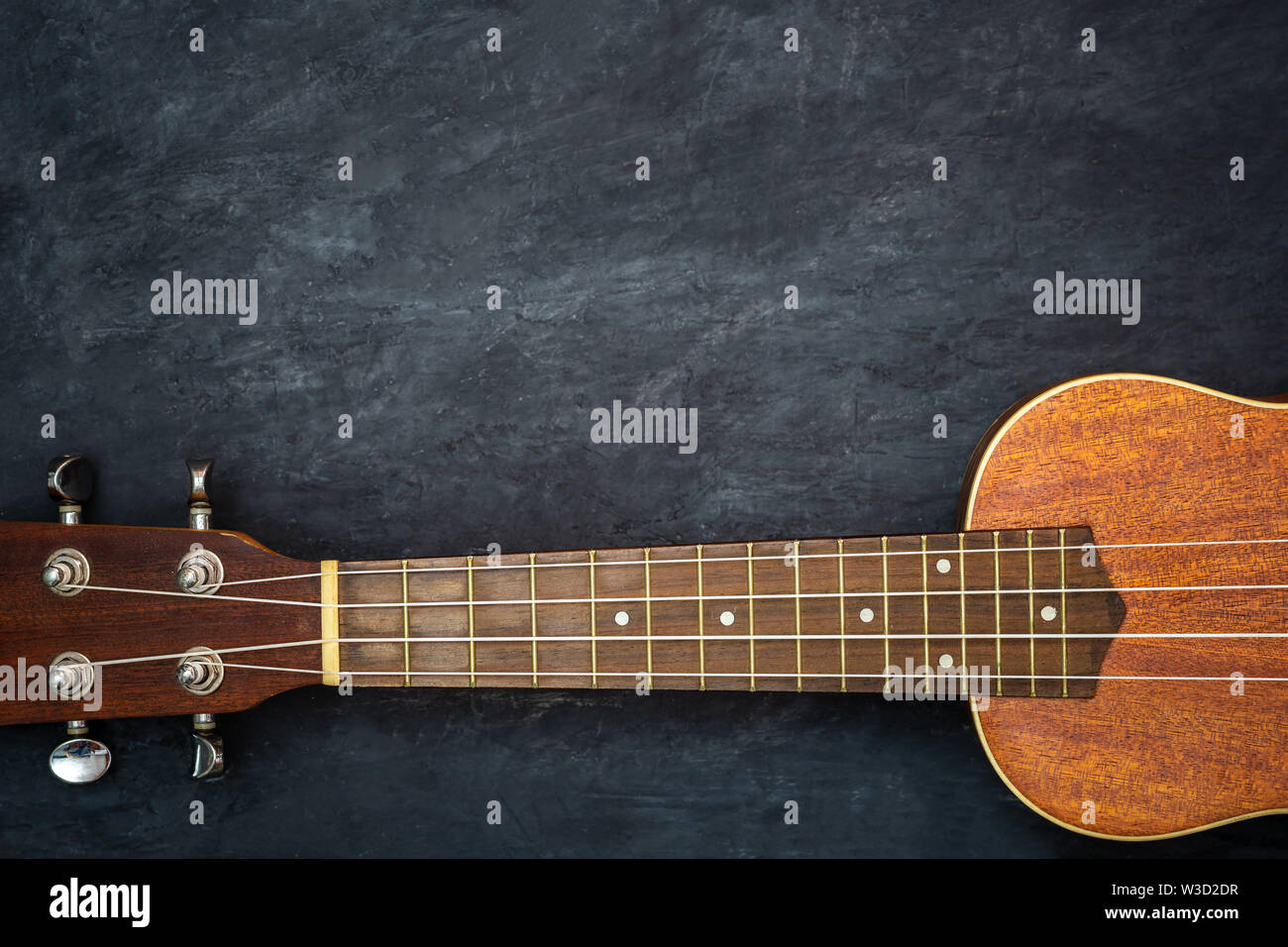 Ukelele negra sobre fondo de cemento. Cuello y cadenas de ukulele piezas.  Espacio para copiar texto. Concepto de instrumentos musicales hawaiana y  los amantes de la música Fotografía de stock - Alamy