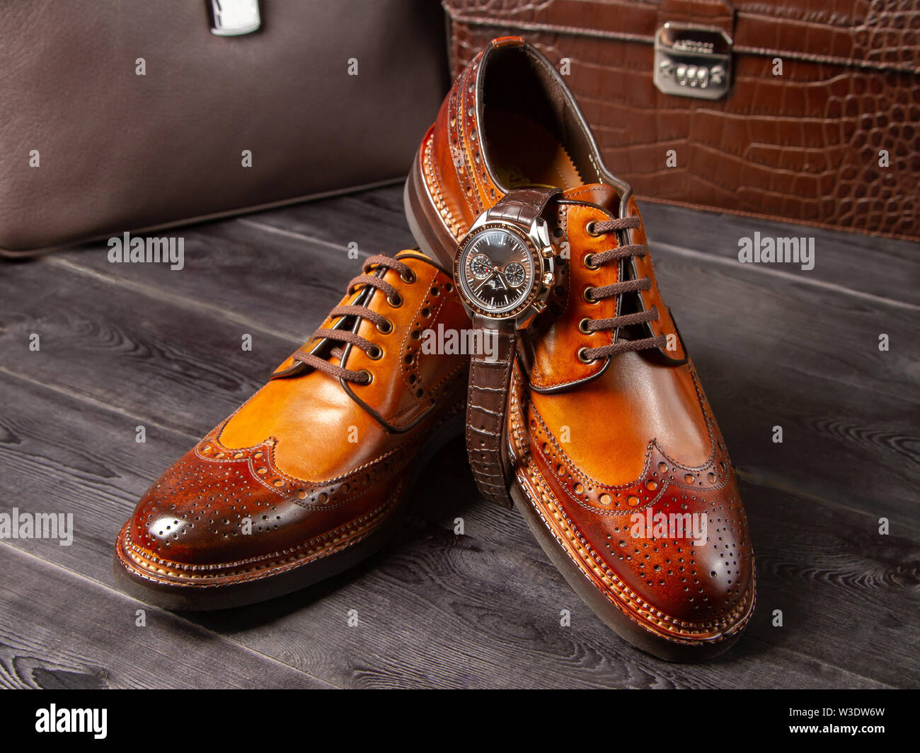 Classic zapatos de hombre de una sombra de color marrón claro, con el telón de fondo los carteras de cuero. Zapatos artesanales cerca. Boss zapatos Fotografía de stock -